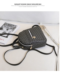Detail of floral pattern on black vintage crossbody bag with dual metal zippers