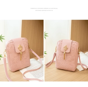 Detail of pink PU leather bag with crown metal buckle, tassels, and embossed floral pattern