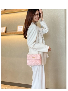 Detail of pink plush crossbody bag featuring quilted patterns and golden chain strap