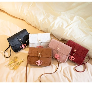 Detailed view of 5 colors small crossbody bags with heart charms and embossed patterns