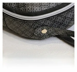 Close-up of fine stitching, silver metal zipper and 'FASHION' print on black backpack