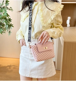 Détail du sac bandoulière rose clair avec fermoir rotatif et sangle large à motifs
