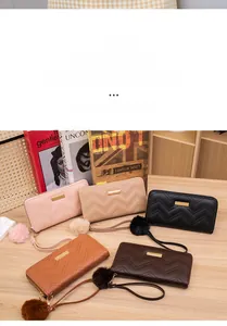 Detailed view of wave-pattern long wallets with gold metal plates and plush pom-pom charms