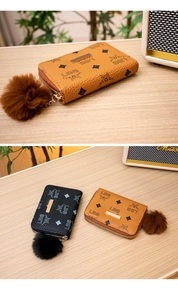 Detail of lychee pattern leather mini wallets with pompom charm and metal zipper
