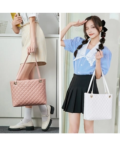 Close-up of quilted diamond pattern and golden eyelets on pink and white tote bags