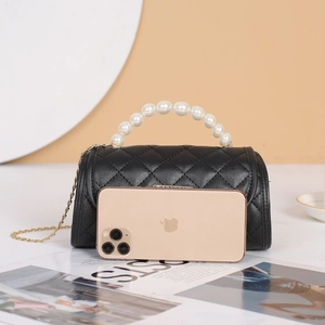 Quilted black cylinder handbag with elegant pearl handle and gold chain shoulder strap