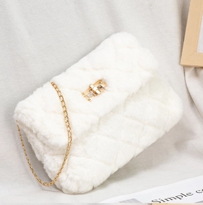 Detail of white plush crossbody bag with quilted faux fur and gold chain strap