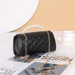 Elegant black quilted barrel bag featuring pearl handle and gold chain strap