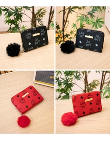Detail of red and black faux leather coin purses with golden bar and plush ball charm