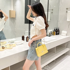 Chic yellow crocodile embossed crossbody bag with gold chain strap on stylish model