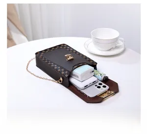 Interior view showing phone and essentials inside a brown monogram crossbody phone bag