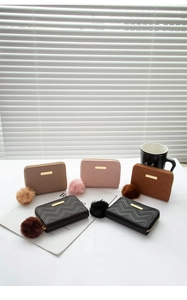 Group display of five colorful PU leather coin purses with quilted V-patterns and pompom charms