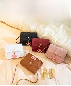 Detailed display of mini crossbody bags in five colors with heart charms and embossing