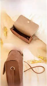 Detail of vintage brown crossbody bag featuring solar embossed patterns and magnetic closure