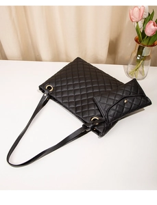 Detail of black quilted tote bag with matching mini pouch and gold hardware accents