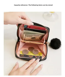 Interior view of black accordion wallet with pink lining, coin pocket and pompom charm