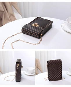Detail view of mini phone bag with geometric print, gold metal lock and chain strap