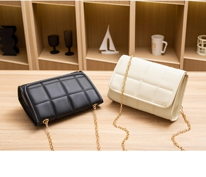 Detailed shot of quilted pattern handbags in black and beige with gold chain straps