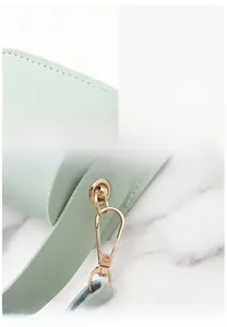 Detail of mint green leather mini bag showing fine stitching and golden metal lobster clasp