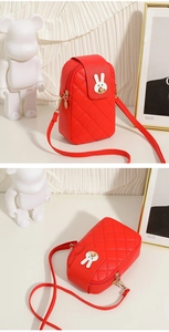 Detail view of red quilted mobile phone bag with a white rabbit metallic buckle
