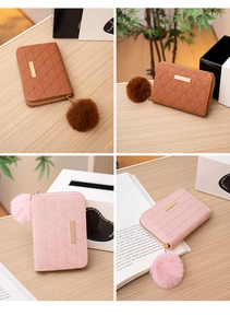 Detail of quilted leather wallet with gold bar trim and plush faux fur pompom keychain