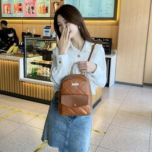 Brown quilted leather backpack with gold metal plate and multiple zipper compartments
