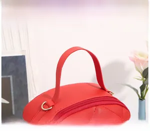 Detail of red quilted leather handle with gold-tone D-ring and metal zipper top