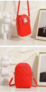 Close-up of red quilted crossbody phone bag featuring a silver rabbit metal clasp