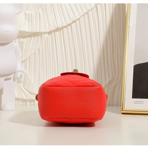 Detailed bottom view of red quilted shoulder bag with gold turn-lock and sturdy base
