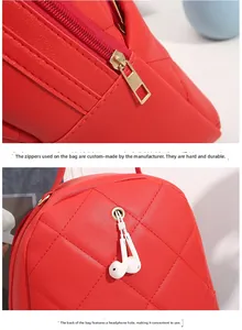 Detail of red quilted backpack showing durable golden zipper and earphone hole