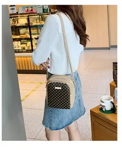 Detailed side view of multi-compartment crossbody bag with geometric pattern and strap