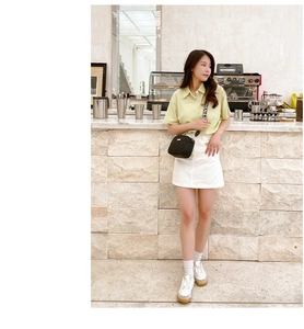 Chic lifestyle view of black quilted crossbody bag with stylish lettered wide strap