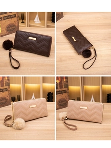 Detail of V-quilted faux leather long wallet with gold bar and fluffy pompom charm