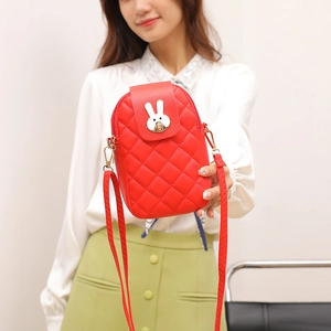 Red quilted crossbody phone bag with silver rabbit buckle worn on white shirt