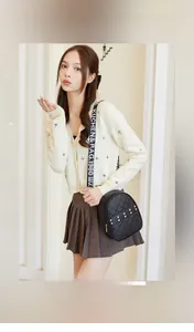 Detail of black quilted shoulder bag with gold studs and printed crossbody strap