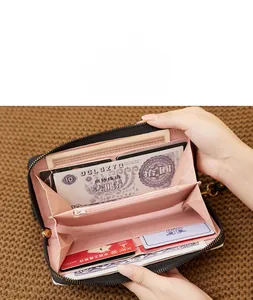 Detail of long leather wallet with pink organ-style interior, card slots and zipper pocket