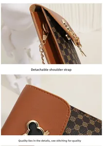 Detail of vintage crossbody bag showing Mickey-shaped lock and clover pattern strap