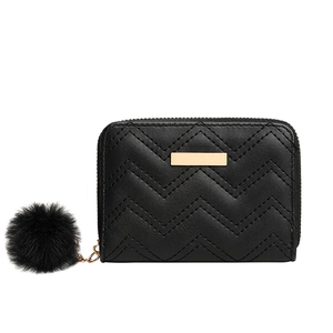 Elegant black quilted mini wallet with gold trim and fuzzy pompom keychain accessory