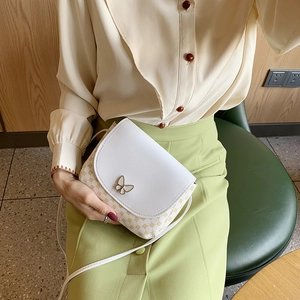 Schicke Muscheltasche mit Polka Dots und Schmetterlingsschnalle von Model getragen