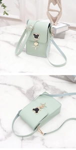 Detail of mint green mini crossbody bag featuring a mickey head metal ornament and strap