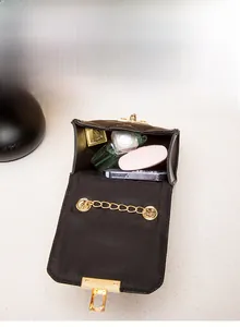 Internal view of the quilted crossbody bag showing compartments for perfume and cards