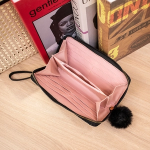 Portafoglio lungo da donna nero in pelle con ciondolo a pompon e cinturino da polso
