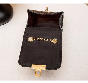 Detail view of the black quilted crossbody bag showing gold chain strap and interior storage