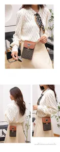 Detail of vintage crossbody phone bag with geometric patterns and metal mouse charm