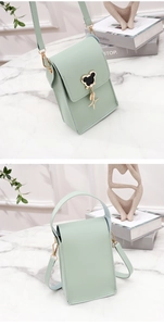 Detail of mint green mini crossbody bag with gold hardware and textured faux leather