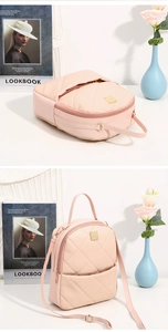 Detailed view of pink quilted leather backpack with gold zippers and diamond stitch pattern