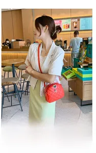 Détail d'un sac bandoulière rouge matelassé avec pendentif souris et zip en étoile