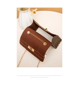 Detail of vintage brown bag showing gold chain strap and textured monogram side pattern