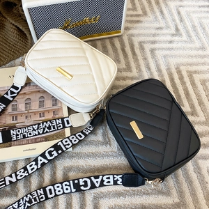 Quilted leather crossbody bags in black and white with golden hardware and wide straps