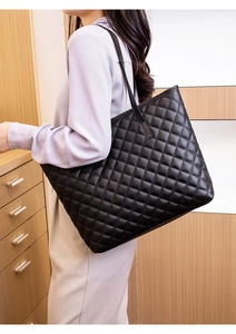 Classic black quilted tote bag shown on shoulder for large capacity daily use
